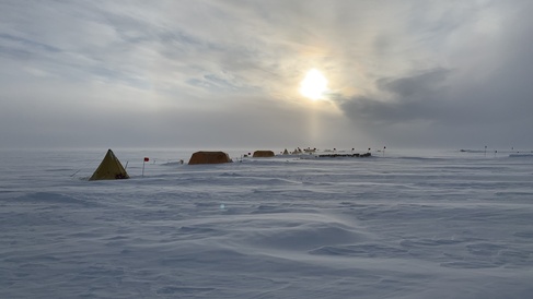 A series of tents set up in a line on the snow in a remote part of Antarctica